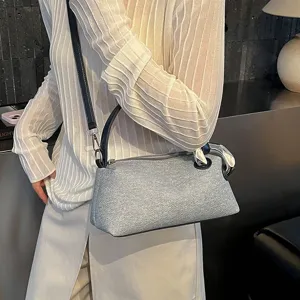 Gros plan détaillé du sac oreiller d'épaule argenté élégant avec sangle noire et anneau en métal.