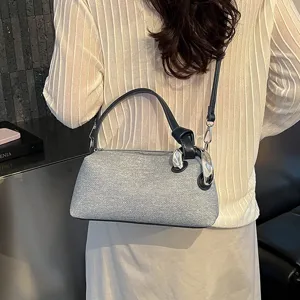 Vue détaillée d'un sac bandoulière oreiller en jean gris tendance avec quincaillerie argentée.