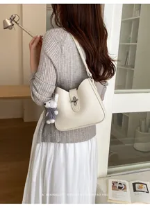 Detailaufnahme der minimalistischen Schultertasche mit feiner Lederstruktur und Schloss.