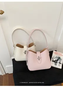 Detailansicht minimalistischer Ledertaschen, elegante weiße und rosa Hobo-Handtaschen.