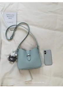 Hellblaue Damen Schultertasche Detailansicht mit Metallverschluss und süßem Strick Hasen Anhänger.