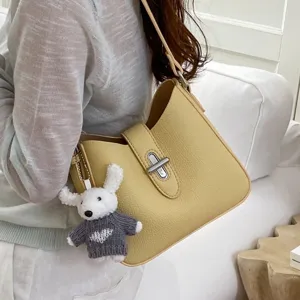 Elegante gelbe Damen Umhängetasche aus Leder, modische Beuteltasche mit süßem Plüschanhänger.