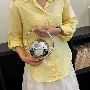 Metallic spherical evening handbag with circular ring handle, stylish unique design for women.