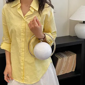 Chic spherical evening handbag with gold ring handle, elegant style for daily commute or parties.