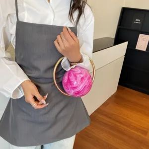 Chic round marble pattern handbag with metal ring handle, trendy niche evening bag for women.