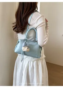Ansicht der stilvollen hellblauen Boston Tasche mit süßem Welpenanhänger, elegantes Retro-Design.