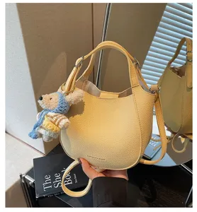 Élégant sac à bandoulière seau en cuir PU jaune avec charmant pendentif ours.