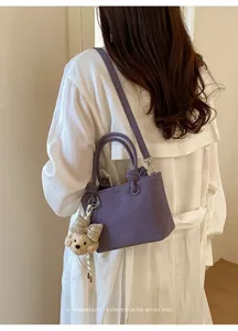 Modische lila Umhängetasche für Damen, vielseitige Handtasche mit süßem Plüschbär-Anhänger.