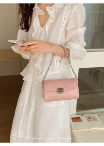 Dettaglio borsa a tracolla rosa, elegante catena in metallo, primo piano lifestyle chic.