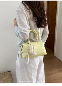Schicke hellgelbe Leder Boston Handtasche mit Umhängeriemen und süßem Plüschhund Anhänger.