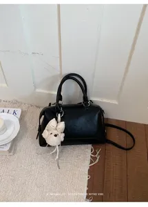 Schwarze PU-Leder Boston Handtasche Detail mit elegantem Retro-Design und Plüsch Anhänger.