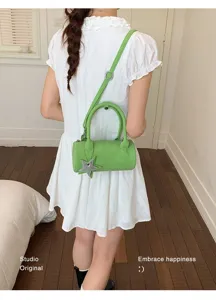 Detailed shot of the trendy green cylindrical shoulder bag with star charm and stylish strap.