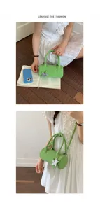 Green cylindrical baguette handbag with star charm, stylish shoulder crossbody bag for women.