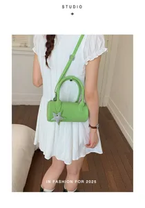 Green cylinder baguette shoulder bag detail showing stylish star pendant and strap design.