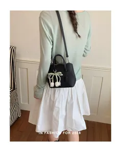 Schicke schwarze Lederhandtasche für Damen mit eleganter Perlen-Tulpen-Anhänger und Schulterriemen.