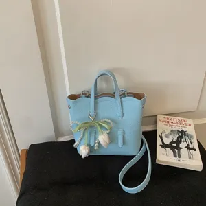Elegante hellblaue Eimertasche mit Perlen-Tulpen-Anhänger, schicke Umhängetasche für Damen.