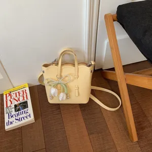Detailansicht der gelben Eimer-Ledertasche mit Perlen-Tulpenanhänger und Umhängegurt.