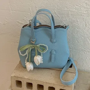 Hellblaue Leder Eimer Handtasche für Damen mit Wellenrand und Perlen Tulpen Anhänger.