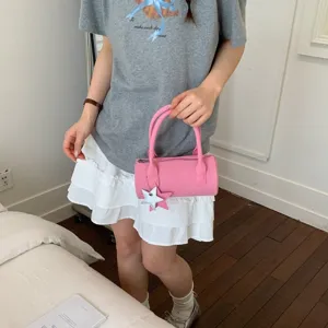 Pink cylindrical handbag for women, cute baguette shoulder bag with star charm for daily use.