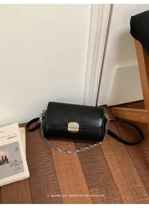Vista dettagliata della borsa quadrata nera da donna con chiusura metallica e finitura elegante.