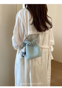 Hellblaue Leder-Eimer Tasche mit geflochtenem Griff stylische Damen Umhängetasche Detail.