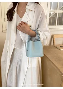 Hellblaue Leder Beuteltasche mit geflochtenem Henkel, schicke minimalistische Handtasche.