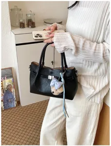 Elegante bolso tote de cuero negro con bonito colgante de oso lazo para moda de mujer chic.