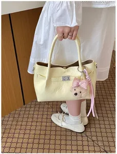 Bolso de mano elegante para mujer en amarillo con bonito colgante de oso y cierre.