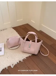 Primer plano detallado de elegante bolso de cuero rosa y estuche a juego en el suelo.