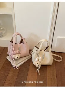 Vista detallada del bolso de cubo para mujer con bonito colgante de oso de peluche.