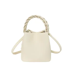 Weißer Leder Eimer Tasche mit geflochtenem Henkel und Umhängegurt für Damen Sommer Mode.