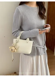 Minimalistische weiße Eimer Tasche mit Bären Anhänger stilvolle Knoten Griff Handtasche