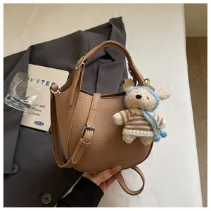 Sac seau élégant en cuir marron avec joli pendentif ours, sac bandoulière quotidien parfait.