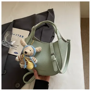 Sac seau chic en cuir vert avec joli pendentif ours, sac à bandoulière élégant pour femmes.
