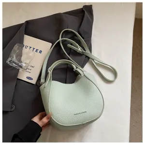 Vue détaillée d'un sac seau vert clair avec cuir texturé et bandoulière réglable chic.