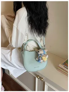 Sac seau vert clair avec charmant pendentif ours tricoté, sac bandoulière élégant et épuré.