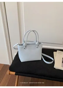 Minimalistische hellblaue Leder Eimer Tasche Detail, schickes Griff und Schultergurt Design.