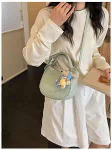 Vue détaillée du sac à main bandoulière vert clair, style minimaliste avec ours.