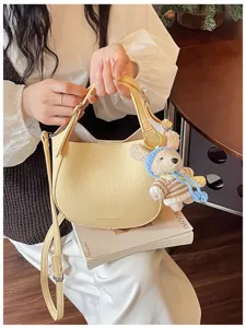 Elégant sac seau en cuir jaune clair avec charmant pendentif ours, sac bandoulière chic.