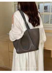 Vue détaillée du sac cabas fourre-tout épaule en cuir texturé marron, style minimaliste.