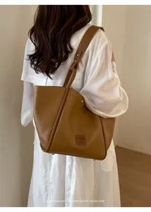 Vue détaillée d'un sac cabas marron minimaliste doté d'une poignée verticale unique.