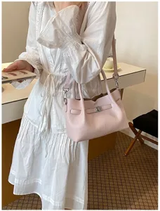 Bolso tote de cuero rosa elegante para mujer con cerradura de metal y bandolera.