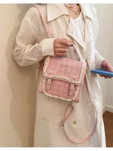 Detailed view of pink plaid mini backpack with sweet lace trim, cute bows, and metal buckle.