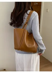 Vue détaillée du sac cabas d'épaule en cuir marron, montrant sa grande capacité et texture.
