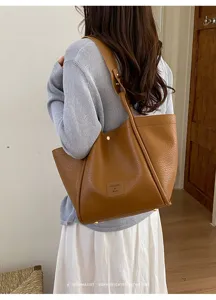 Vue de détail cabas rétro minimaliste, grand sac porté épaule élégant aux finitions soignées.