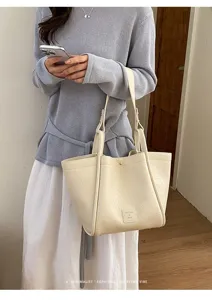 Vue de détail d'un sac cabas beige chic à texture douce, style rétro minimaliste pour femme.