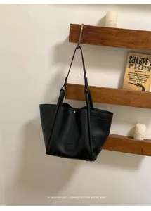 Sac cabas en cuir noir sac seau minimaliste sac bandouliere decontracte avec poignees.