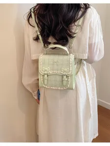 Green tweed mini backpack detail, featuring cute bows and delicate lace trim for daily use.