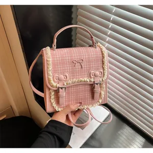 Close-up of a pink plaid mini backpack with cute lace trim and bows for women detail shot
