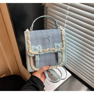 Detailed view of the cute blue plaid mini backpack with lace trim and sweet bow design.